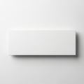 The image showcases a simple, white rectangular object placed on a flat surface. The object has a smooth, matte finish and casts a Royalty Free Stock Photo