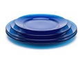A stack of vibrant blue ceramic plates with a glossy finish on a white background Royalty Free Stock Photo