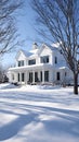 Snowy Landscape Featuring White Farmhouse Style Home with Columns and Dormers Royalty Free Stock Photo