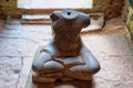 Image showcasing a damaged sculptural representation of Buddha in an ancient Cambodian temple, with notable decapitation,