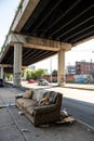 Trashed sofa under overpass, design architecture