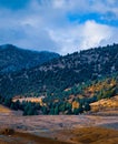 Image showing green mountains surrounding a dry valley showing arrival of autumn.