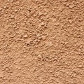 An image showing a textured surface of beige, coarse sand or soil mixed with small Royalty Free Stock Photo