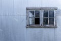 Grungy old window on a corrugated metal shed wall Royalty Free Stock Photo