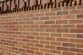 Brown brick wall texture background with header of protruding bricks in geometric shapes Royalty Free Stock Photo