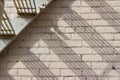 Abstract view of an old gray fire escape staircase in front of a vintage brick wall Royalty Free Stock Photo