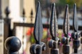 Antique traditional black iron fence post spires along an urban sidewalk Royalty Free Stock Photo