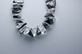 Macro abstract view of a vintage hematite and quartz crystal necklace on white background with copy space