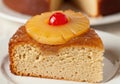 A slice of pineapple upside-down cake on a white plate with a blurred background Royalty Free Stock Photo
