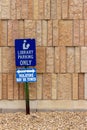 View of a library parking sign in front of an modern limestone wall with rough texture bricks