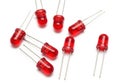 Assorted red light-emitting diodes with metal leads on a white background Royalty Free Stock Photo