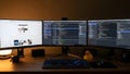 Three computer monitors on a desk with a keyboard and a rubber duck Royalty Free Stock Photo