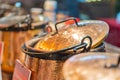 Image shows a display of varying copper pots and pans on a counter, each with handles The pots vary in size for Royalty Free Stock Photo
