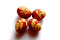 The image shows four red eggs with intricate yellow leaf patterns displayed against a white background Royalty Free Stock Photo