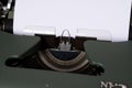 The image shows a green typewriter with a white sheet of paper on it Royalty Free Stock Photo