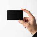 The image shows a hand holding a black rectangular object. The object appears to be flat and smooth, and the background is plain Royalty Free Stock Photo