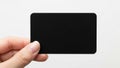 A person holding a blank black business card against a white background Royalty Free Stock Photo