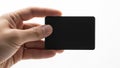 A hand holding a small black rectangular object against a white background Royalty Free Stock Photo