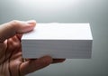 A hand holding a stack of neatly arranged white blank paper sheets Royalty Free Stock Photo