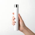 A hand holding a tall white bottle with a silver cap against a white background Royalty Free Stock Photo