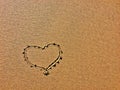 The image shows a heart shape drawn in the sand with fine grains Royalty Free Stock Photo