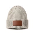 Cozy knit beanie with a brown leather patch for a stylish winter accessory Royalty Free Stock Photo