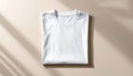 the image shows a neatly folded white shirt with a round neckline placed on a plain surface. the shirt is precisely centered, and Royalty Free Stock Photo