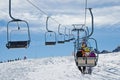 Chairlift above ski resort in winter with people shown from behind