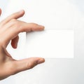 A hand holding a small white rectangular object against a plain background Royalty Free Stock Photo