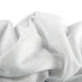 Softly drapeed light-colored fabric against a plain background Royalty Free Stock Photo