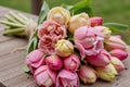 The image shows pink and yellow tulips on a wooden table with a blurred background Royalty Free Stock Photo