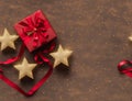 A red ribbon tied around a gift box with a bow on top, surrounded by three gold stars. - seamless and tileable Royalty Free Stock Photo