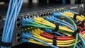 A complex network of colorful cables connected to a server rack Royalty Free Stock Photo