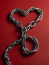 The image shows a silver chain forming a heart shape against a red background, symbolizing strong, linked love or passion Royalty Free Stock Photo