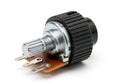 Close-up view of a potentiometer with black knob and three terminals on orange circuit board Royalty Free Stock Photo