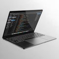 A modern laptop displaying lines of code on a black and silver background Royalty Free Stock Photo