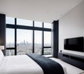 A luxurious bedroom with a large window overlooking the city skyline. Royalty Free Stock Photo