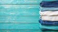 A stack of folded blue jeans and white shirts on a blue wooden background. Royalty Free Stock Photo