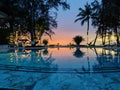 A swimming pool at a resort during a sunset.Â The scene is illuminated by string lights hanging above the pool Royalty Free Stock Photo