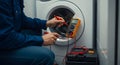 technician diagnosing a washing machine with a multimeter, showcasing appliance repair and maintenance in a modern laundry setting Royalty Free Stock Photo