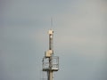 Image shows a tower with multiple structures, possibly communication equipment, on a clear day Tower has platforms for