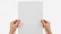 Two hands holding a blank white sheet of paper against a plain background Royalty Free Stock Photo
