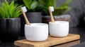 A wooden tray holds two white cups with toothbrushes in them, placed on a black countertop. Royalty Free Stock Photo
