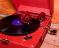 Image shows vintage gramophone famous Czech brand Supraphone. The red wind-up gramophone and vinyl record brand Royalty Free Stock Photo