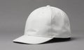 white baseball cap with flat brim and small holes on the front is shown against gray background. Royalty Free Stock Photo