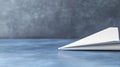 A white paper airplane on a blue surface. Royalty Free Stock Photo