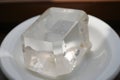 The image shows a white plate on a table with an ice cube on top with blurred background Royalty Free Stock Photo