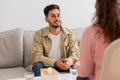 Young man talking to a woman therapist on couch Royalty Free Stock Photo