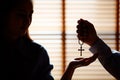 Image is Silhouette. Asian man is giving a cross to a Christian woman with a smiling face. To pray to Jesus Confession to God. Royalty Free Stock Photo