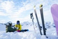 Image of skis, ski poles, snowboard against background of two sports women with thermos sitting in ski resort in winter Royalty Free Stock Photo